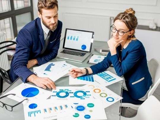 A man and women reviewing analytics and metrics at a table