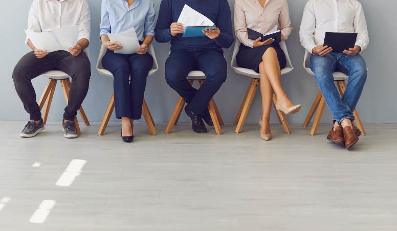 Group of people sitting in chairs waiting for interviews