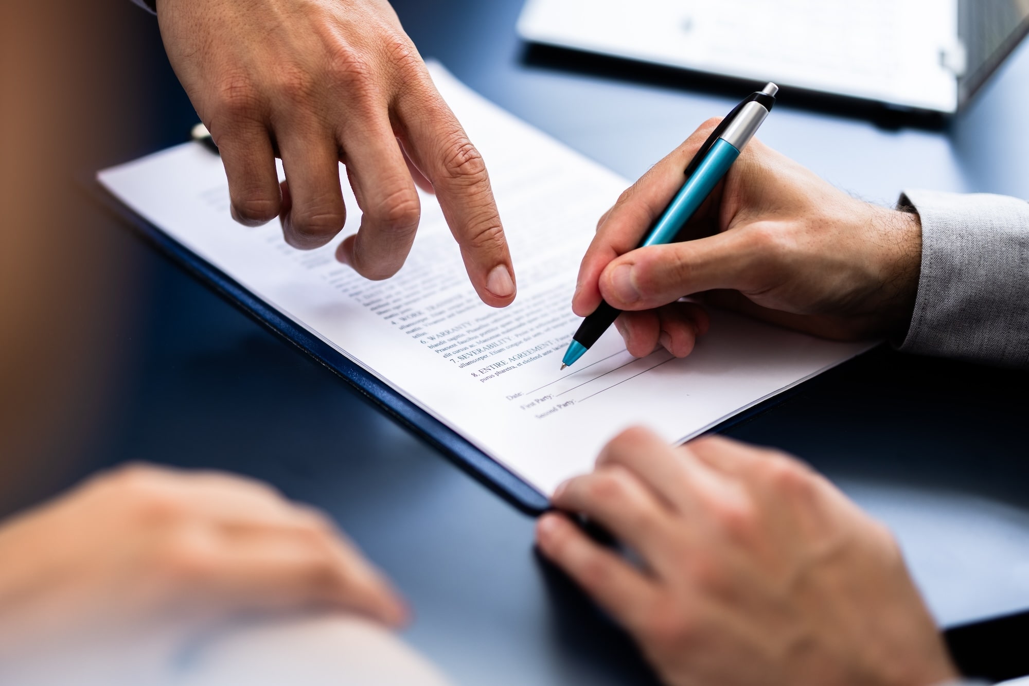 Man signing contract at desk