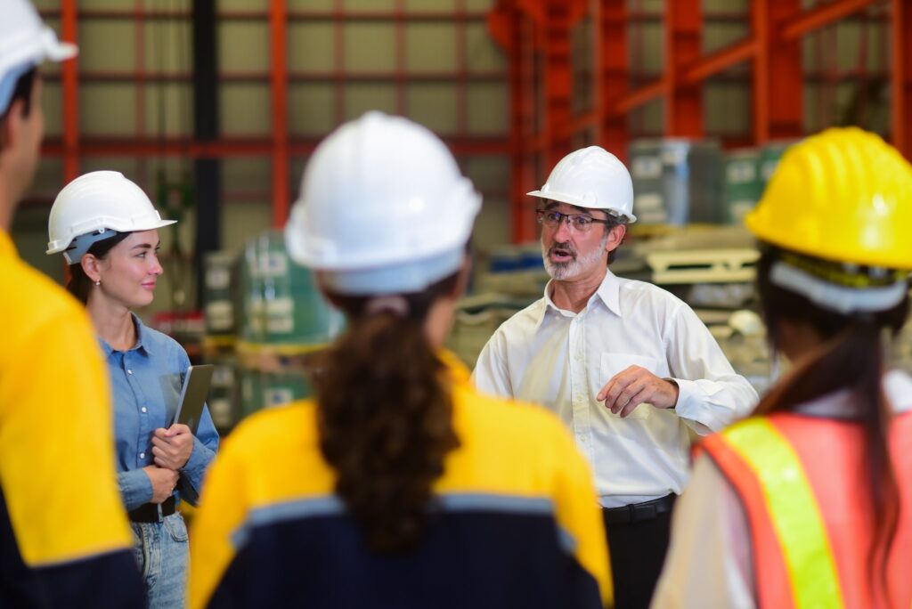 Manufacturing employees wearing hardhats and vests
