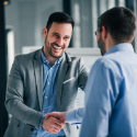 Two men smiling, shaking hands