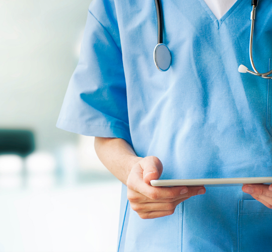 Nurse wearing stethoscope and holding tablet