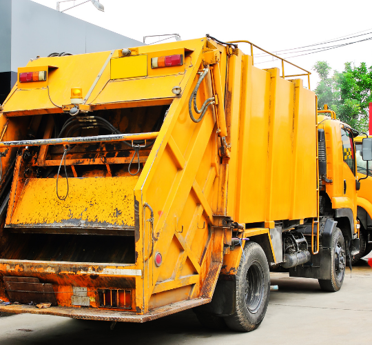 bright yellow garbage truck outside